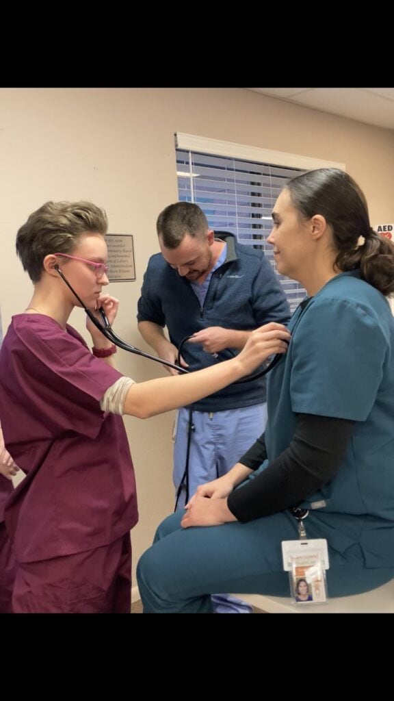 Kei Seiban practices vital signs on Dr. Sarah Coles with the supervision of Dr. Dakota Wise during the Fall 2023 Future Faces of Family Medicine program.