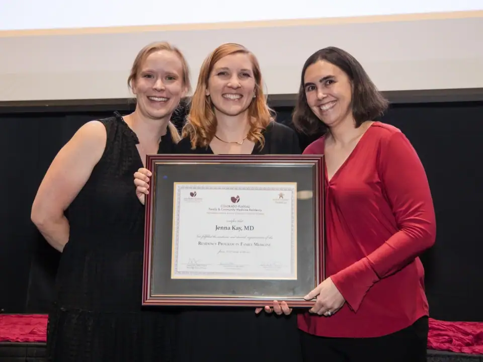 Dr. Jenna Kay (center) receives her residency diploma from her advisor, Dr. Julia Forberg (left) and Program Director Dr. Sarah Coles (right) at the graduation ceremony on June 28th.